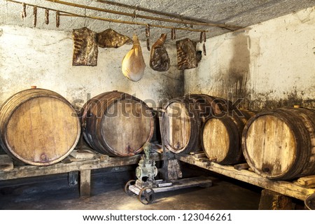 Interior of very old wine cellar with vintage wine pump and dried meat delicatessen-grunge brown toned