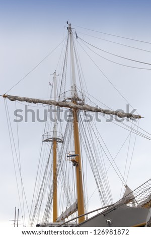 Front view of vintage sailing ship mast and sails against sky