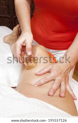 Woman receiving a professional anti cellulite massage with Ventuza vacuum body puller, while lying on a towel in a awarded health massage center,  series of HQ close-up photos