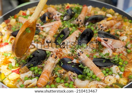 Stiring tasty organic paella with seafood and chicken breast