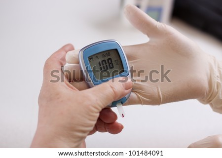 Geriatric nurse measures with glucose meter