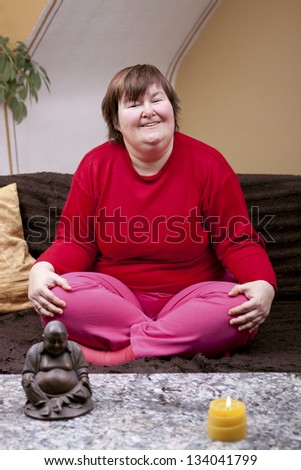 mentally disabled woman sitting cross-legged on the couch