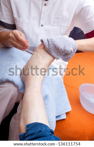 Geriatric nurse washes the foot of a senior
