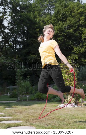 Young woman jumping rope in the garden