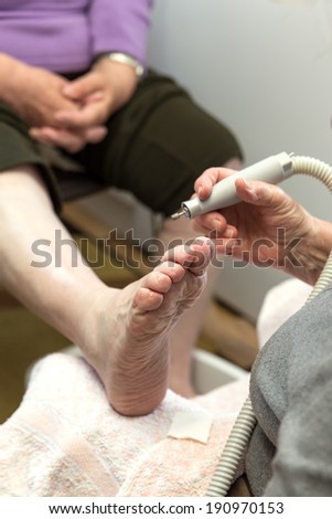 chiropodist at a senior woman at home