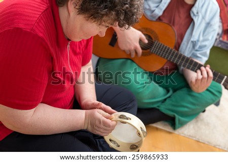 a mentally disabled woman playing a tambourine