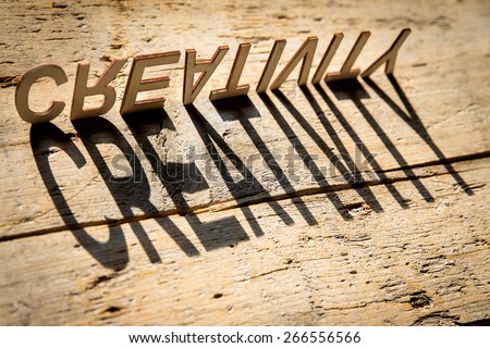 wooden letters on old aged wooden table build the shadow word creativity, vintage style