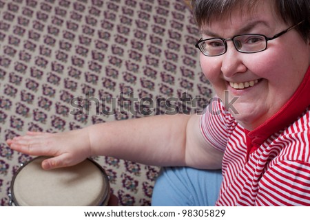 a sitting mentally disabled woman make music and looks excited