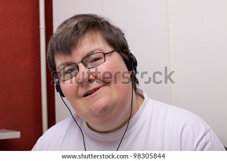 a sitting mentally disabled woman is listening to music