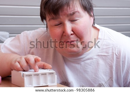 mentally disabled woman with some pills looks afraid