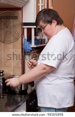 a mentally disabled woman is cooking in the kitchen