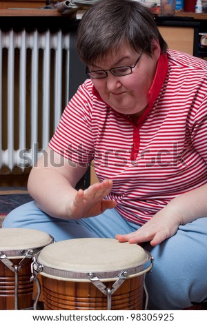 a sitting mentally disabled woman make music and looks excited