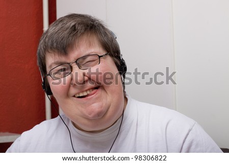 a sitting mentally disabled woman is listening to music