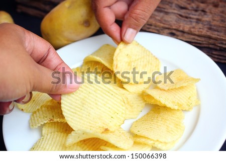 Close up of potato chips and fresh potato