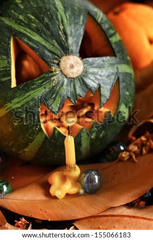 Scary Jack O Lantern halloween pumpkin on dry leaves