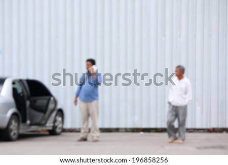 Blurred of man calling insurance after car accident
