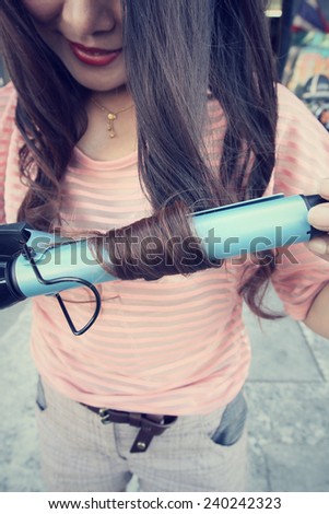 Woman using straightener with hair