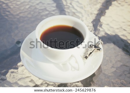 Hot coffee and necklace with cross