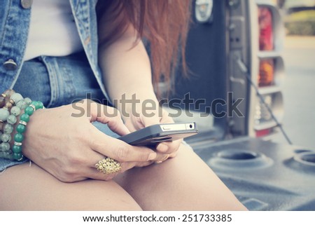 Woman using smart phone on truck