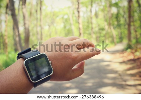 Woman hands with smartwatch in forest