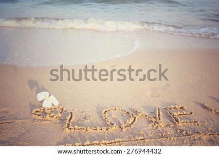 The word love written in sand on beach