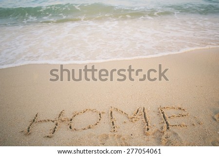 The word home written in sand on beach