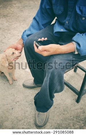 Senior man using smart phone with dog