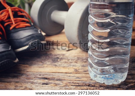 Sports set of sneakers, dumbblell and water drink