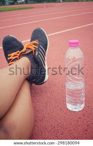 Sport shoes with water drink on track