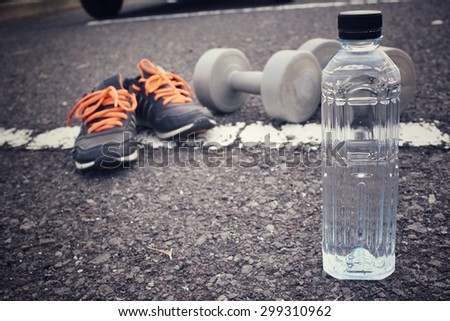 Sports set of sneakers dumbblell and water drink