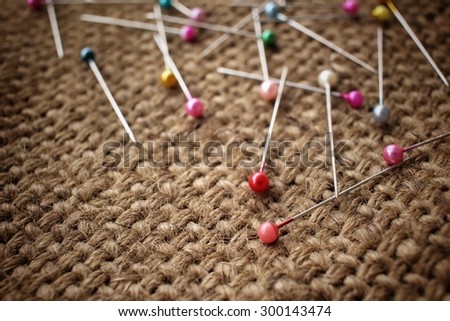 Colorful sewing pins on sackcloth