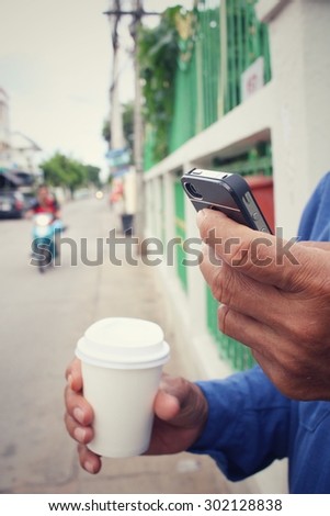 Man drink coffee paper cup with smart phone