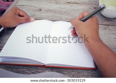 Woman with pen writing on paper