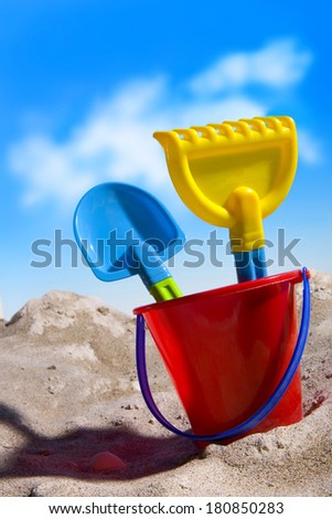 beach toys on the sand with blue sky and clouds, scene fake staged in the studio