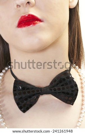 black bow tie worn by a model with red lips and white pearl necklace