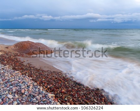 The sea wave rolls on a stony beach.