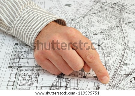 architect pointing with his finger at the solution on a very messy construction plan