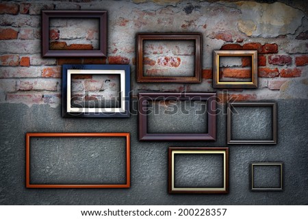 different painting frames hanging  on cracked ancient wall