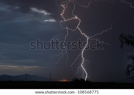 Thunderstorm and dark blue sky with lightning over power plant in Arizona, USA, during summer monsoon/Cloud to Ground Lightning Strike at Twilight during Thunderstorm/Lightning in summer thunderstorm