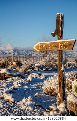 Homemade parking sign during a sunny and snowy winter's day in desert Southwest USA/Parking Sign in Desert Snow Landscape during Winter/Parking sign on a sunny morning in winter