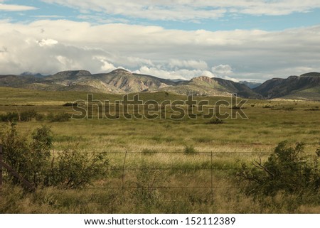 Green grasslands with mountains of Chiricahua National Park in Coronado National Forest in southeastern Arizona, USA, in summer after monsoons/Mountains to Grasslands/Ranch land turns green in summer