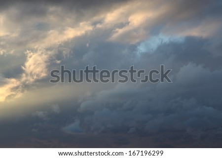 Evening sunlight on wispy tops of clouds, while a sun ray reaches into soft gray clouds/Sunlight and a Sun Ray touch the Cloudy Heavens of Soft Grays/Sunshine lights up the gray cloudy sky