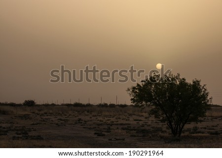 Sun sets in thick sky of dust in semi-desert region of southwestern United States/Dust Pollution in Atmosphere over Dry Land at Sundown/Heavy dust from dry dirt covers setting sun over dry land