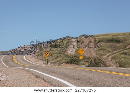Hilly landscape with paved two-lane USA highway and road sign, HILLS BLOCK VIEW...Stay Right/Paved Two-Lane USA Road and Sign, HILLS BLOCK VIEW..STAY RIGHT, in Hills Landscape/Hilly USA road and signs