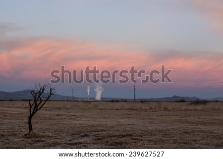Semi-desert landscape with white steam from power plant rising to pink clouds at twilight/White Columns of Steam from Power Plant rise up to Pink Clouds at Twilight in Landscape/Power plant steam