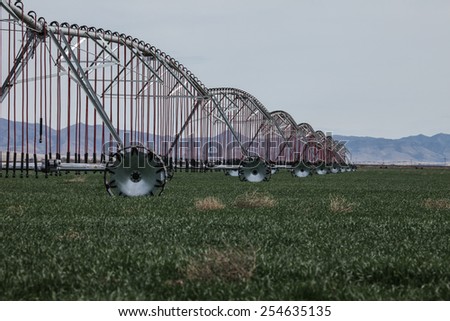 Landscape of pivot sprinkler system for crop irrigation/Farmland with Center-Pivot Water Sprinkler System for Circle Crop Irrigation in Southwestern United States/Scenic of new pivot irrigation system
