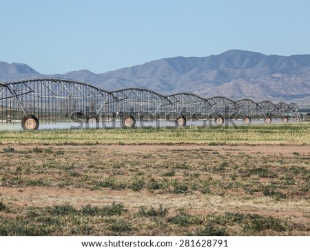 Landscape of center-pivot sprinkler irrigation system watering new crop field/Scenic of New Farm Field being Watered by Pivot Sprinkler Irrigation Method/Crop irrigation by pivot sprinkler system