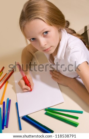 little girl with blond hair draws