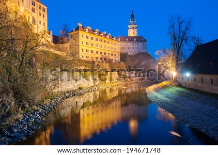 Castle with the famous round tower in Cesky Krumlov, Czech Republic is reflecting in the river Vltava in the evening