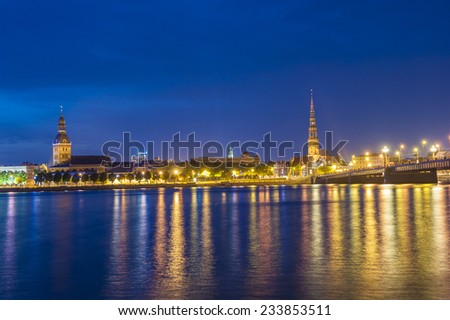 Skyline of Riga seen across the river Daugava after the sunset. The tallest building on the picture is the St. Peter\'s Church